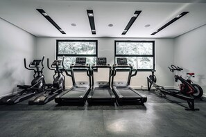 Ein Fitnessstudio mit Laufbändern, Crosstrainern und Rudergeräten.
