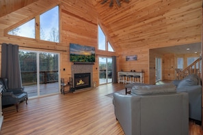 A spacious living room with a fireplace, large windows, and a staircase. - Peaches & Streams, Blue Ridge, GA (Morganton)