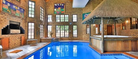 Una piscina techada, sillones reclinables de piscina