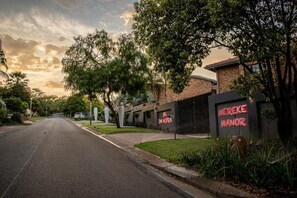 A street view with a building labeled 'MEREKE MANOR' and a road leading into the distance.