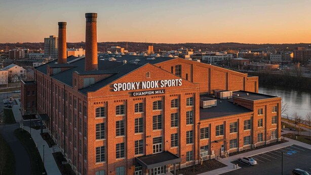 Un edificio de ladrillo con el letrero "Spooky Nook Sports Champion Mill" al atardecer.