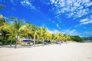 A beach with palm trees and beach umbrellas. - Jungle Hideaway · Private Pool & Beach Club (La Cruz de Huanacaxtle)