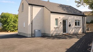 Un bâtiment d’un seul étage, doté d’un toit en pente, d’un petit porche et d’une porte de garage.