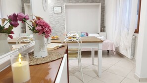 Ein modernes Zimmer mit Esstisch, Stühlen, einem Bett und einem Badezimmer.