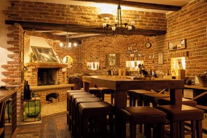 A rustic interior with exposed brick walls, a wooden bar area, and a fireplace. - Villa Experience with swimming pool (Baderna)