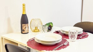 A dining table with a bottle, a glass, a decorative bowl, and a plate. - Cà 4 Nevodi Nonna Chiara Destro by Ca-Sa Check (Chioggia)