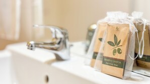 A bathroom sink with a clear glass bottle and two packaged hair and body wash products. - Cà 4 Nevodi Nonna Chiara Destro by Ca-Sa Check (Chioggia)