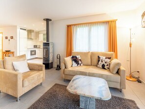 Ein modernes Wohnzimmer mit Sofa, Sessel und einem Marmortisch.