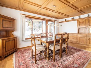 Ein Essbereich mit Holztisch und -stühlen, einem gemusterten Teppich und Holzschränken.