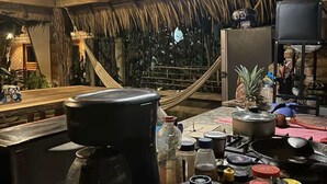 A kitchen with a thatched roof, a coffee maker, and various kitchen utensils. - Private Room with A/C 400 m from Delfines Beach (Bajos de Chila)