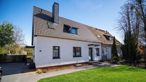 A modern two-story house with a tiled roof, a front porch, and a well-maintained lawn. - Liv OG Vacation Rental in Rechlin: with a garden, Wi-Fi, and private parking (Rechlin)