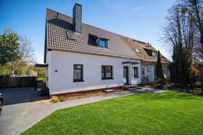 A modern two-story house with a tiled roof, a front porch, and a well-maintained lawn. - Liv OG Vacation Rental in Rechlin: with a garden, Wi-Fi, and private parking (Rechlin)