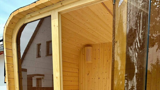 A wooden sauna with a glass door, wooden benches, and a ventilation system. - Liv OG Vacation Rental in Rechlin: with a garden, Wi-Fi, and private parking (Rechlin)