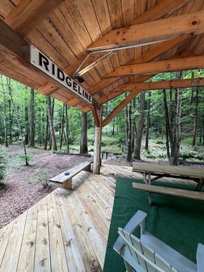 A wooden pavilion with a sign reading 'RIDGELINE,' surrounded by a forest. - Ridgeline Treehouse at Cherryfield Luxury Camping (Brevard)