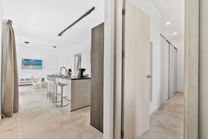 Eine moderne Küche mit einer zentralen Kochinsel, Barhocker und einem großen Fenster.