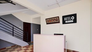 A reception desk, a staircase, and two signs indicating 'HOTEL' and 'OYO-Serviced' in a building. - Classic Seven Hills (Bengaluru)