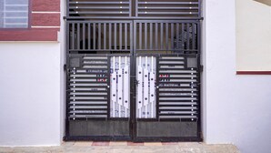 A double door with metal bars and a window to the left. - Classic Seven Hills (Bengaluru)