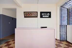 A reception desk with a framed religious picture above it and a sign indicating the hotel name and OYO service. - Classic Seven Hills (Bengaluru)