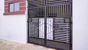 Ein Gebäudeeingang mit einem Metallgitter, einem Fenster und einer Tür mit Beschilderung.