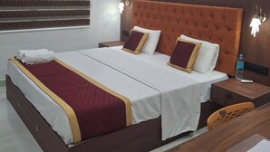 A hotel room with a bed, bedside tables, a desk, and a chair. - 5 Mins to Metro | 15 Mins to Airport – Perfect Launchpad for Explorers! (Aluva)