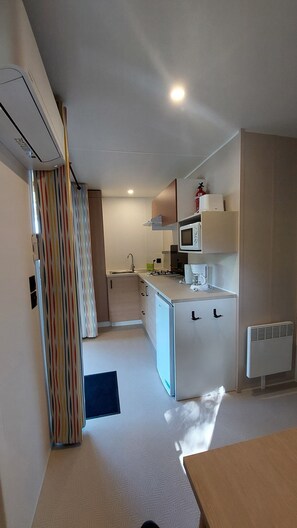 A compact kitchen with a microwave, coffee maker, and a small refrigerator.