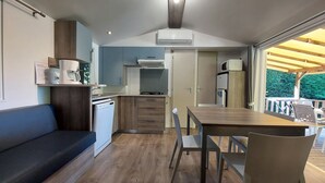 A compact kitchen with a dining area, a built-in oven, and a refrigerator.