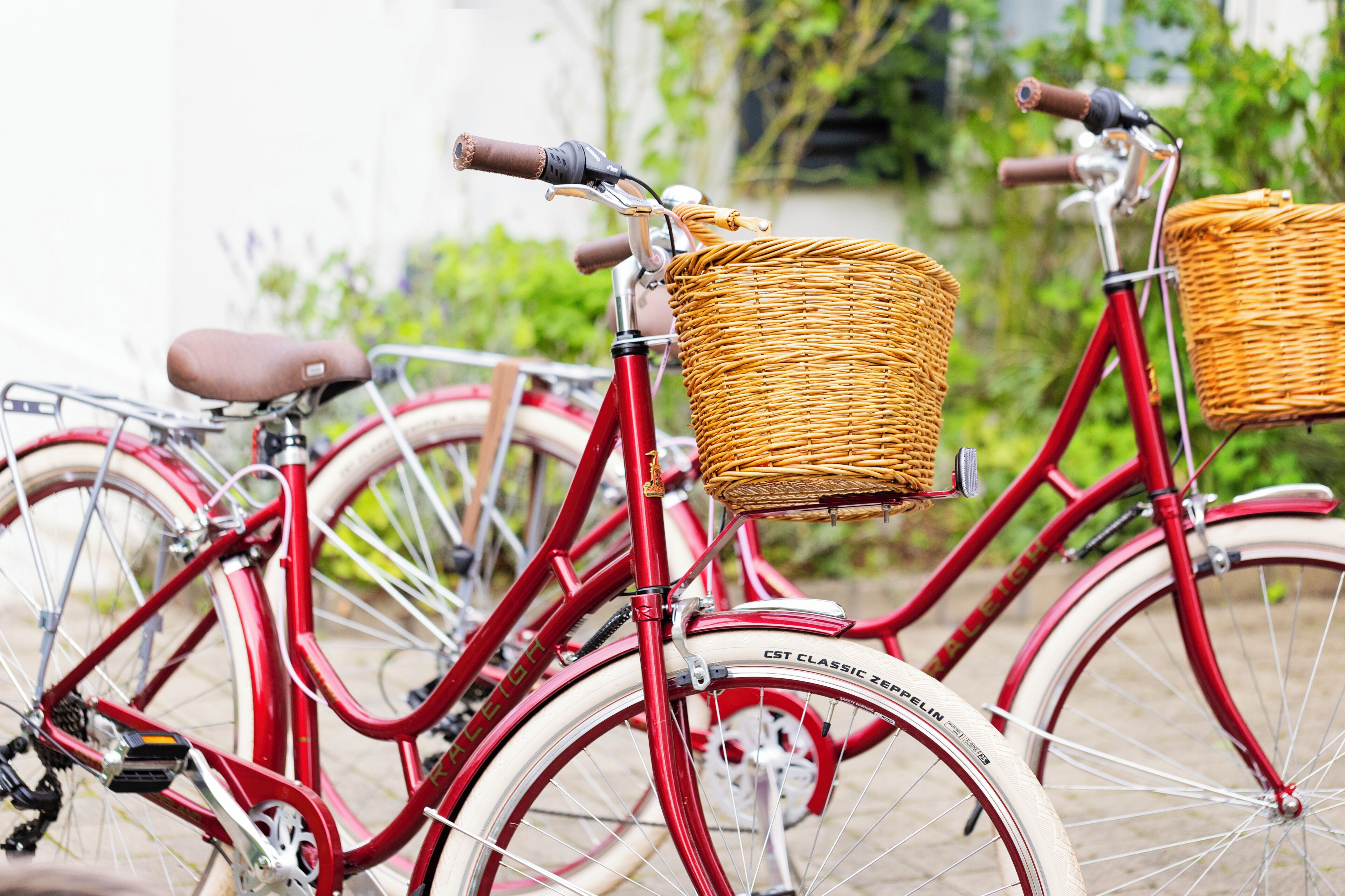 A red bicycle with a wicker basket attached to the front.