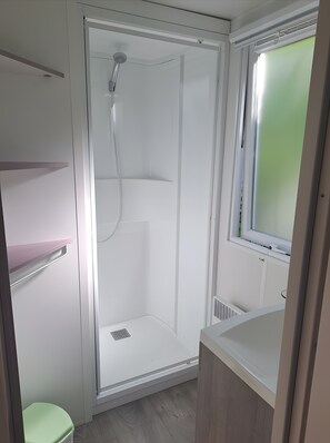 Ein Badezimmer mit Dusche, Toilette und Waschbecken.