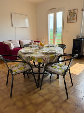 A dining area with a round table set for four, surrounded by chairs with floral upholstery.