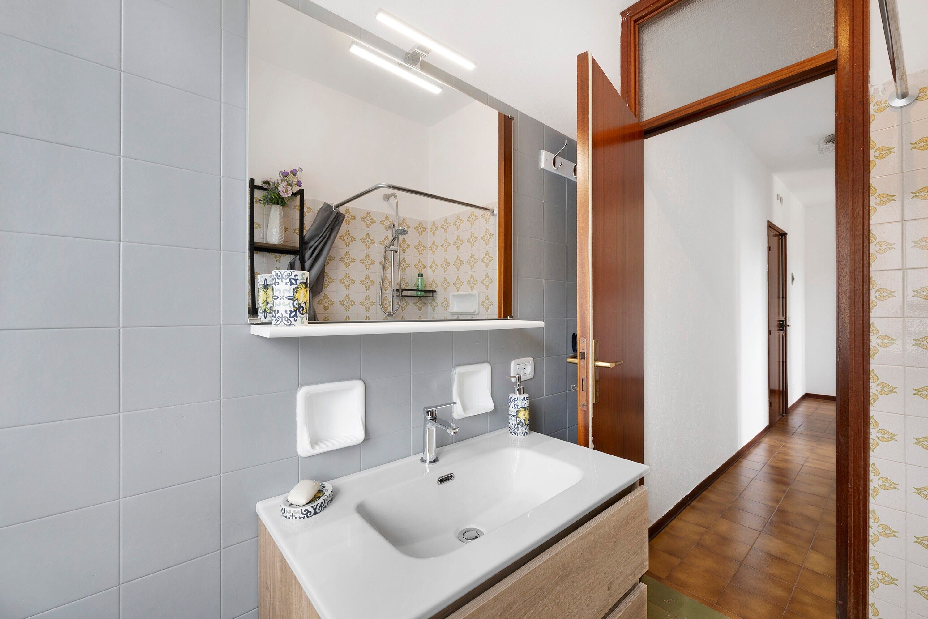 A bathroom with a large sink, mirror, and towel rack.