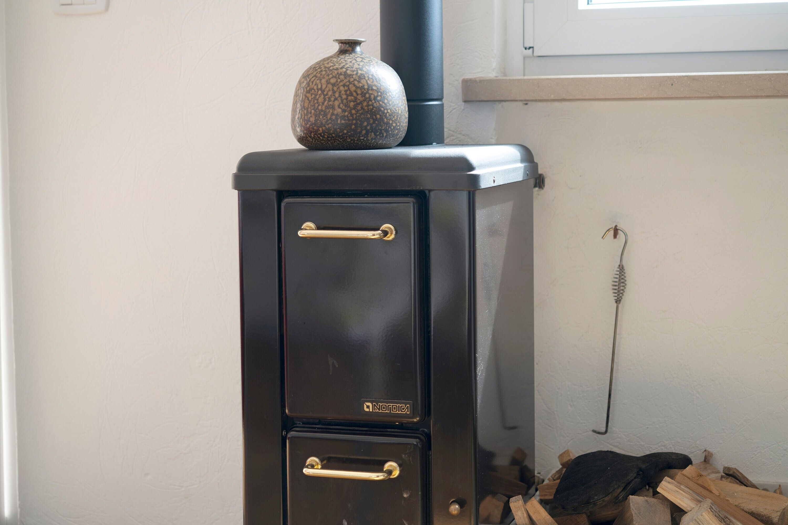 Ein schwarzer Kaminofen mit zwei Türen und Schornstein.