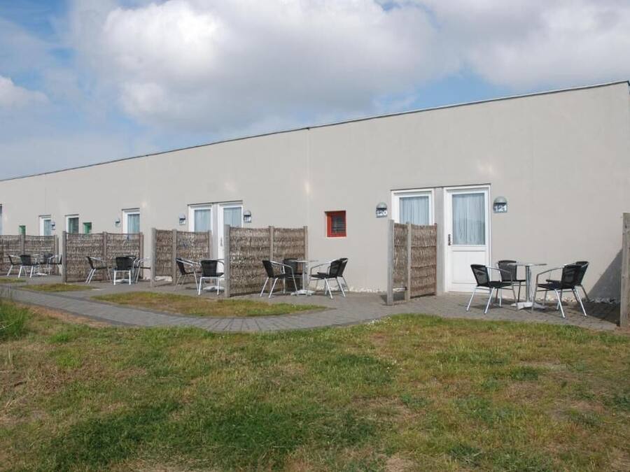 Filetta di cabine individuali, ciascuna con una porta, un piccolo oblò e un numero.