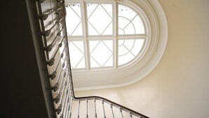 A curved staircase with a white railing and a large window at the top. - Charming mansion with terrace - Jardin Public (sleeps 8) (Bordeaux)