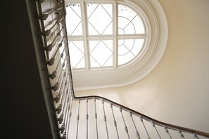 A curved staircase with a white railing and a large window at the top. - Charming mansion with terrace - Jardin Public (sleeps 8) (Bordeaux)