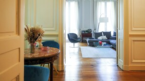 A room with a dining table, chairs, a sofa, and a lamp. - Charming mansion with terrace - Jardin Public (sleeps 8) (Bordeaux)