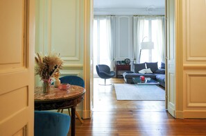 A room with a dining table, chairs, a sofa, and a lamp. - Charming mansion with terrace - Jardin Public (sleeps 8) (Bordeaux)