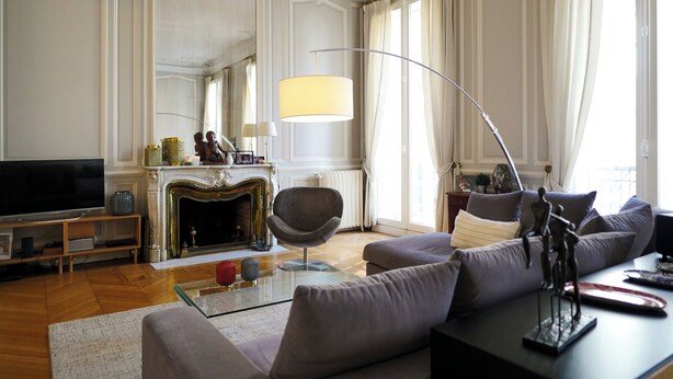 A living room with a television, sofa, armchair, fireplace, and a large window with curtains. - Charming mansion with terrace - Jardin Public (sleeps 8) (Bordeaux)