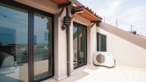 Ein Gebäude mit großen Glasüren, einer kleinen Klimaanlage und einem geneigten Dach.