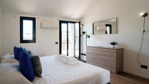 Quarto com cama, cómoda, espelho e janela.