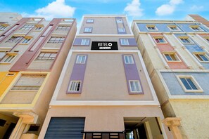 A multi-story hotel building with a sign reading 'HOTEL OYO Serviced'.