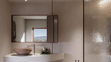 Un baño moderno con un espejo grande, un lavabo sobre encimera y vistas al exterior.