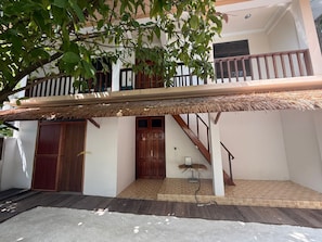 A two-story building with a balcony, a staircase, and a door.