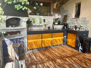 Eine rustikale Küche mit Steinwand, Holzschränken und einem eingebauten Backofen.