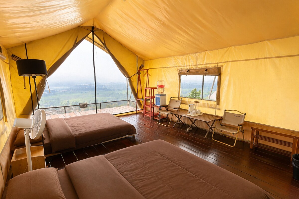 Alojamiento con carpa que incluye dos camas, una mesa con sillas, un ventilador y una ventana con vistas.