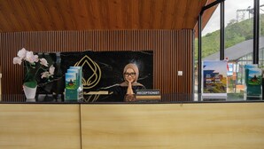 Una recepción con un diseño de panel de madera, una orquídea en maceta y un cuadro enmarcado.