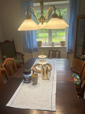 Ein Esstisch mit einer Lampe, einer Kanne, einer Tasse und einer Dekoration.