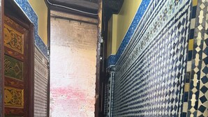 A room with a patterned floor, a red carpet, and a door with intricate designs.