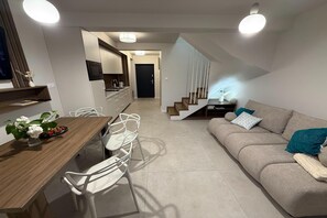 Ein zeitgemäßer Wohnraum mit Essbereich, Küche und Treppe.