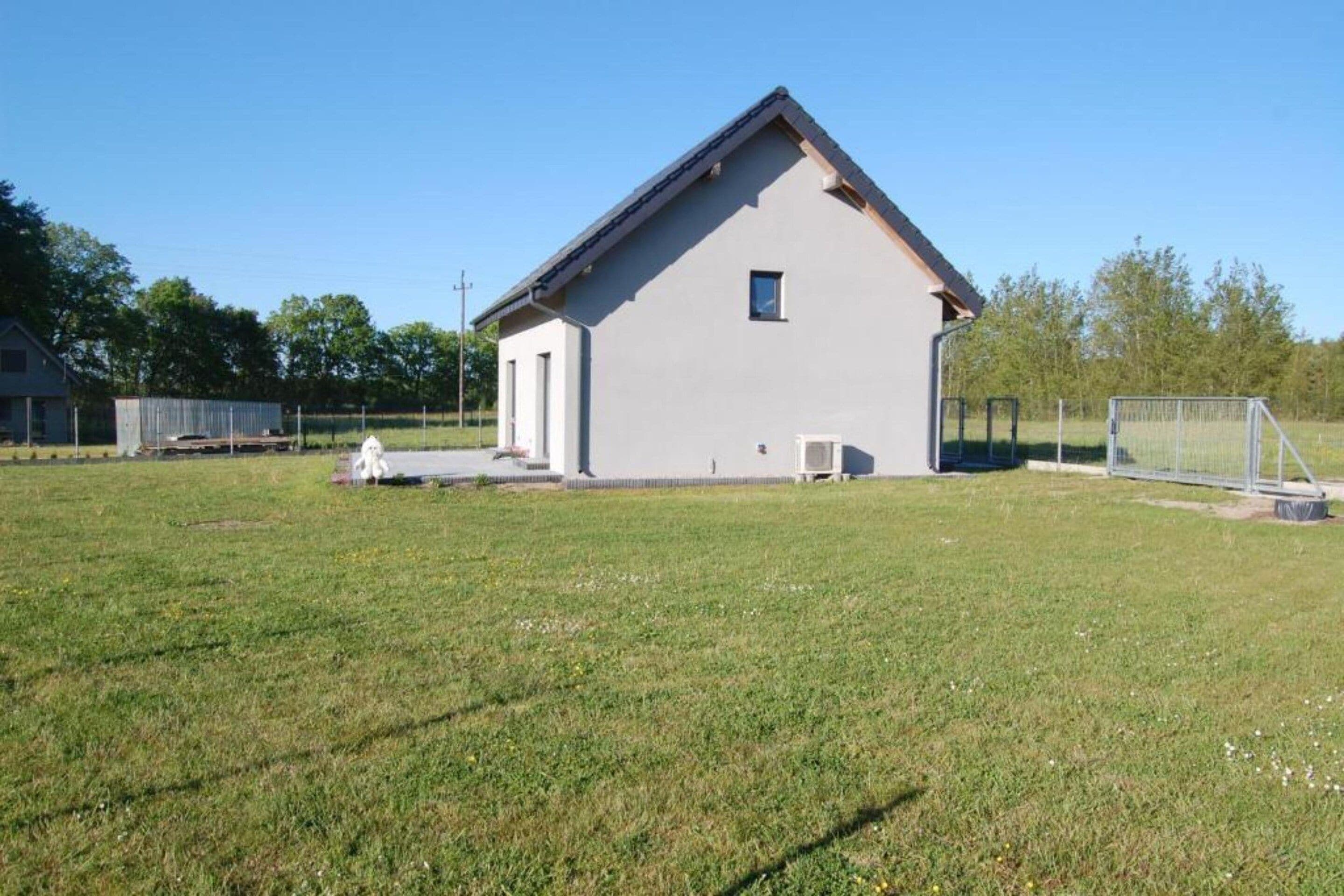 A single-story building with a gabled roof, a small window, and a door on the front side.