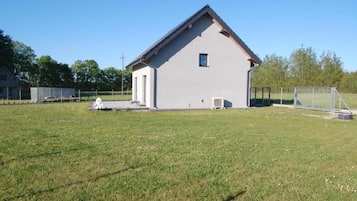 A single-story building with a gabled roof, a small window, and a door on the front side.